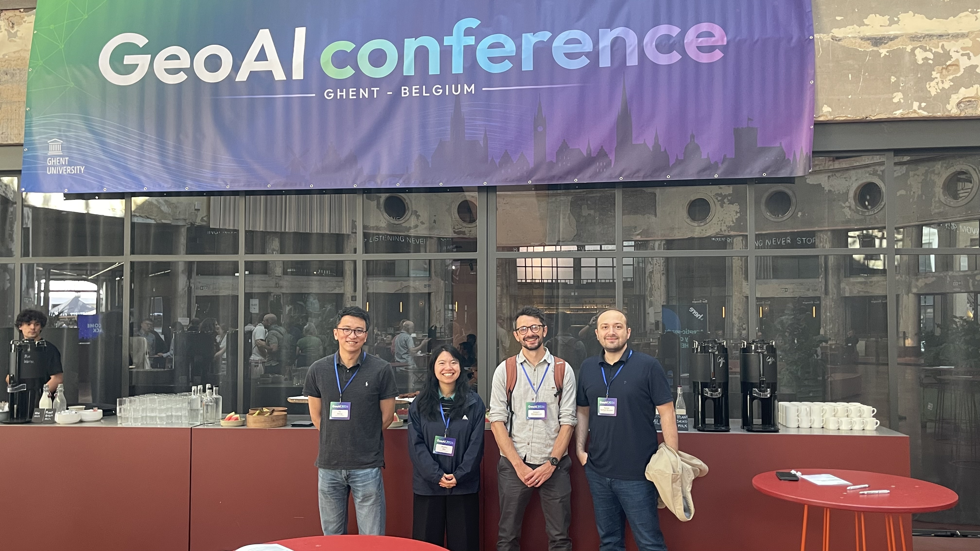 Colleagues gathered beneath the GeoAI conference banner