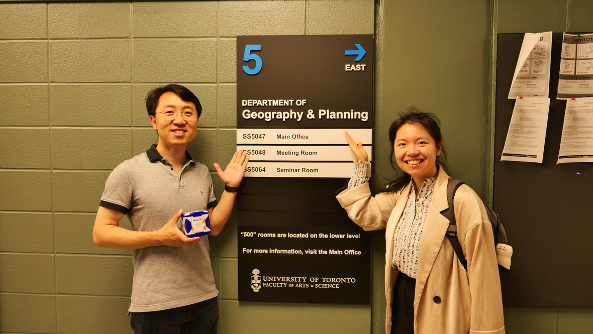 A photograph with a host by the Department of Geography and Planning sign
